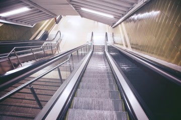 Naklejka premium empty escalator and stair in pedestrian subway railway station. Stairs from metro underground upward. travel concept. Europe. 
