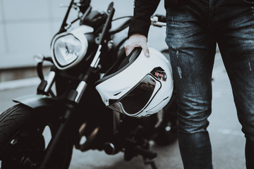 Biker Holds Moto Helmet. Motorcycle On Background. - obrazy, fototapety, plakaty