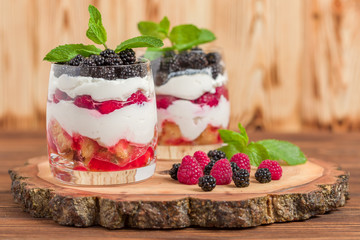 Trifle close up photography with fresh multi layered dessert with dairy and ripe raspberries and blackberries.