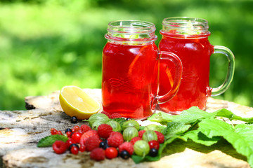 Drink Summer from Mix Berries Decorated with Green Mint. Compote in in a glass jar with a straw....