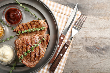 Tasty grilled steak with different sauces on metal tray