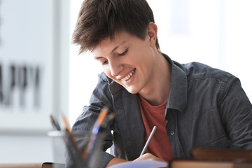 Happy teenager boy doing homework at home