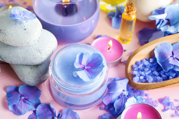 Obraz na płótnie Canvas Spa composition with hydrangea flowers and cream in jar on color table