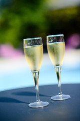 two glass of cool champagne wine outdoor in a restaurant pool side terrace in sunny summer day