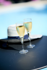 two glass of cool champagne wine outdoor in a restaurant pool side terrace in sunny summer day