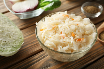 Bowl with delicious sauerkraut on wooden table