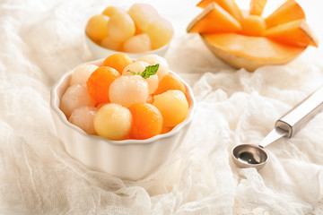 Bowl with delicious melon balls on table