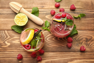 Glasses of fresh raspberry mojito on wooden table