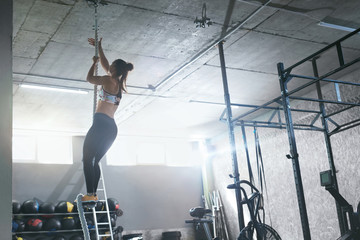 Training At Gym. Female Crossfit Athlete Climbing Rope