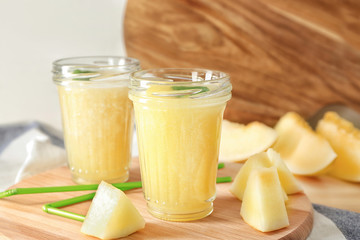 Glass jars with delicious melon smoothie on board