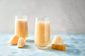 Glasses with delicious melon smoothie on light table