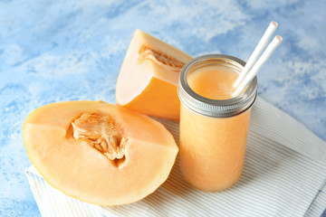 Glass jar with delicious melon smoothie on light table