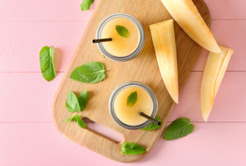 Glass jars with delicious melon smoothie on board