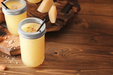 Glass jar with delicious melon smoothie on wooden table