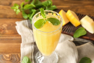 Glass with delicious melon smoothie on table, closeup