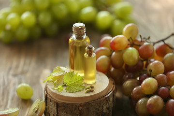 Bottles with grape seed oil on wooden stand