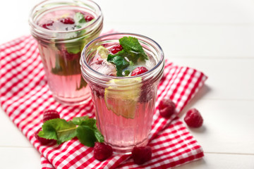Jars of fresh raspberry mojito on table