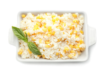 Dish with tasty boiled rice and corn kernels on white background