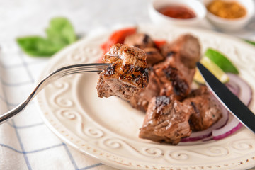 Eating of delicious shish kebab, closeup