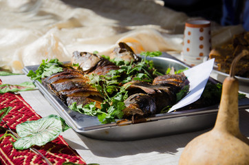 Traditional Bulgarian food on the tray at the fair at the festival. Baked fish with parsley and...