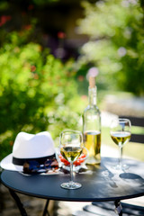 two glass of cool white wine with bottle outdoor in restaurant terrace during a sunny summer day