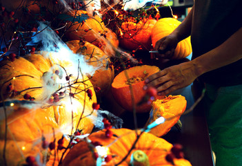 preparing for Halloween, cleaning and carving faces from pumpkins, pumpkins on a dark table with...