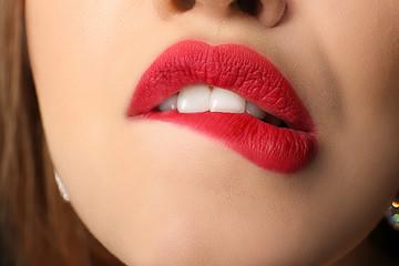 Obraz premium Beautiful young woman with bright red lipstick, closeup