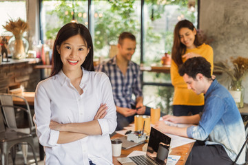 Portrait Asian business woman over group of young creative team working in cafe