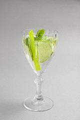 Glass of fresh mojito on light background