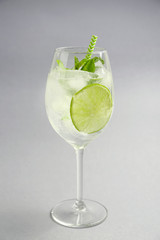 Glass of fresh mojito on light background