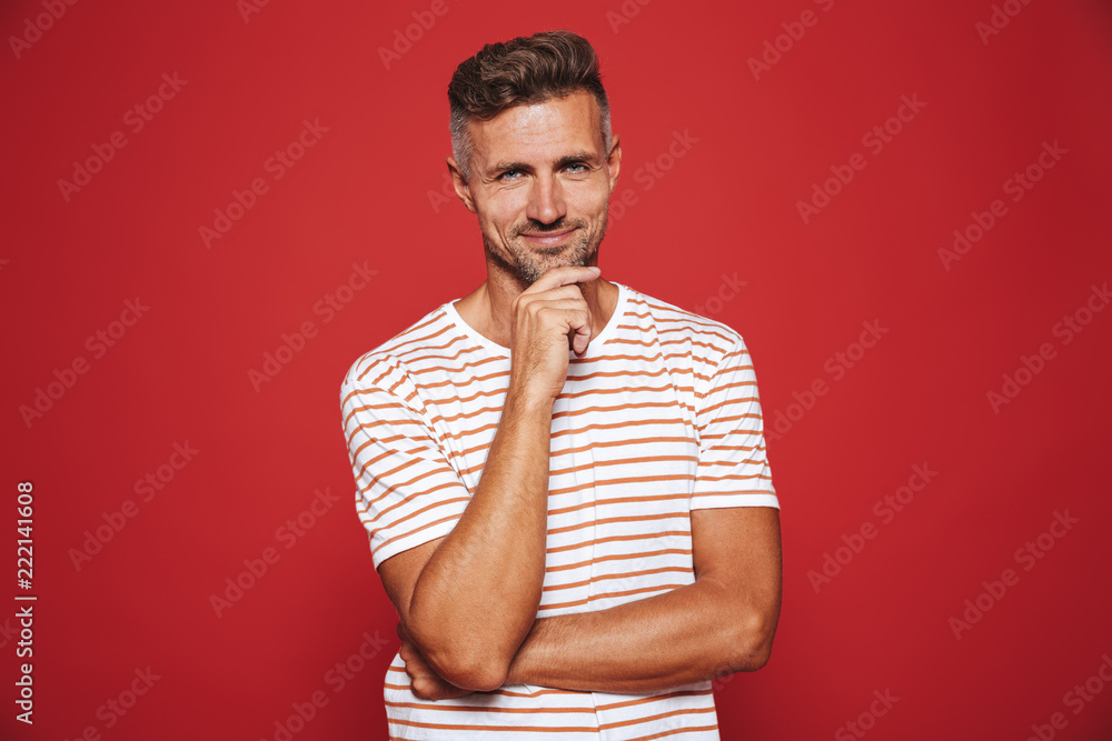 Sticker caucasian man in striped t-shirt thinking and touching chin, isolated over red background