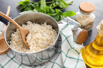 Saucepan with boiled rice on grey table