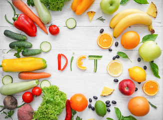 Composition with healthy products and word DIET on light wooden background