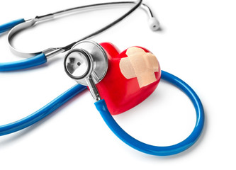 Medical stethoscope and red heart with plaster on white background. Cardiology concept