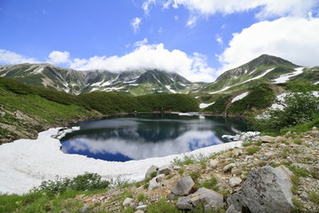 Fototapeta na wymiar 残雪が残る夏のみくりが池と立山連峰