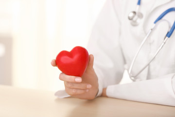 Cardiologist with red heart in clinic, closeup