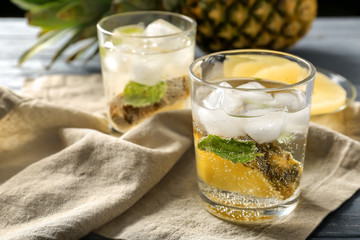Tasty drink with ice and pineapple in glass on napkin