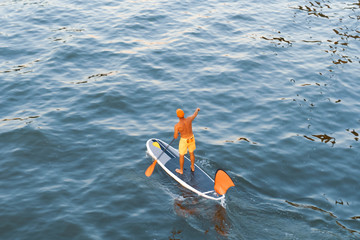 Man stand up paddleboarding on a river