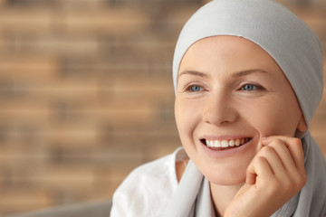 Portrait of happy woman after chemotherapy on blurred background