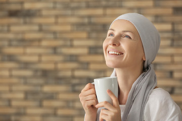 Happy woman after chemotherapy drinking tea at home