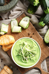 Bowl with delicious zucchini soup on board