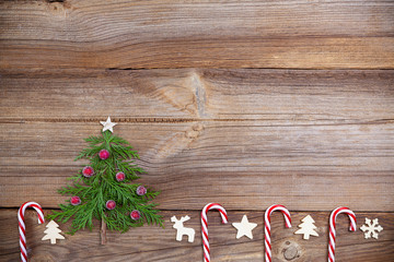 christmas tree on wooden board with candy canes and wooden decorations