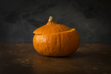 Halloween pumpkin with cut top removed at dark background