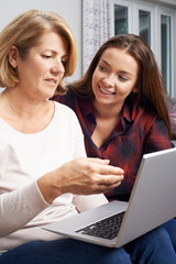 Teenage Daughter Showing Mother How To Use Laptop Computer