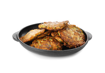 Frying pan with tasty zucchini pancakes on white background