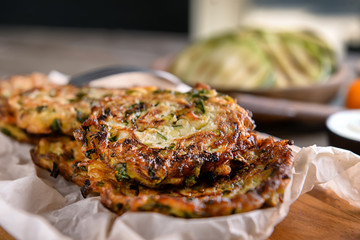 Tasty zucchini pancakes on board, closeup