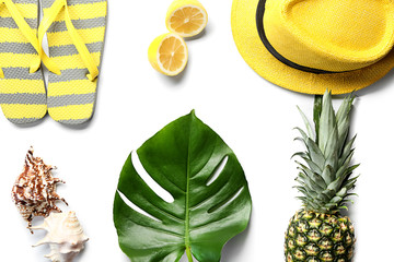 Fresh monstera leaf, fruits and beach accessories on white background