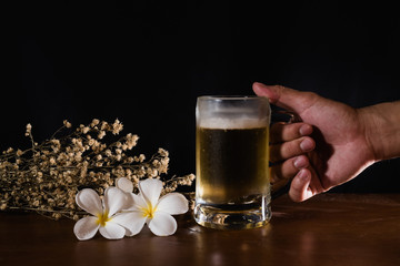beer on wood table and black background