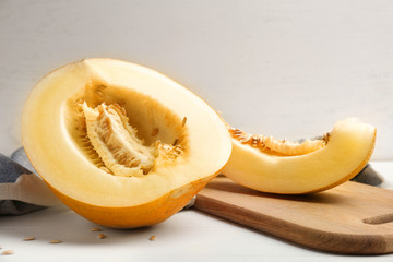Board with ripe sliced melon on white table