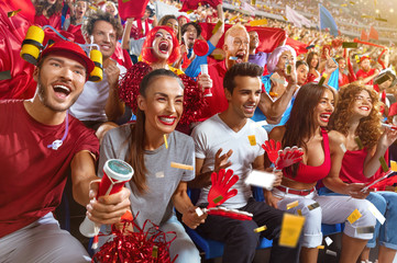 Young sport supporter happy fans cheering at stadium. Group of young woman and man support the...